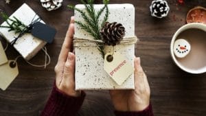 hand presenting a gift with a tag saying presence
