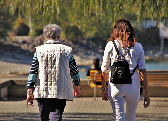 two women walking in the park during the fall