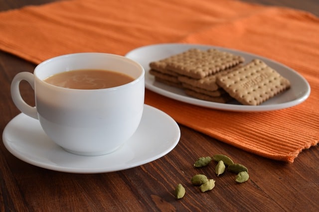 coffee with cardamon pods with biscuits