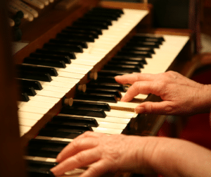 older adult hands playing keyboard