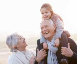 grandparents with grandchild on shoulders