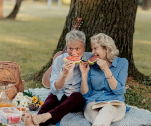 senior couple on picnic enjoying watermelon