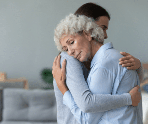 senior woman embracing younger one grief