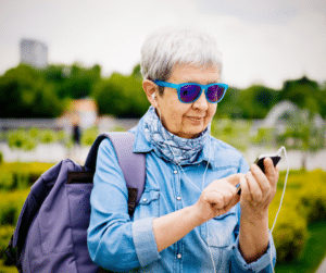 senior woman on vacation with phone and backpack